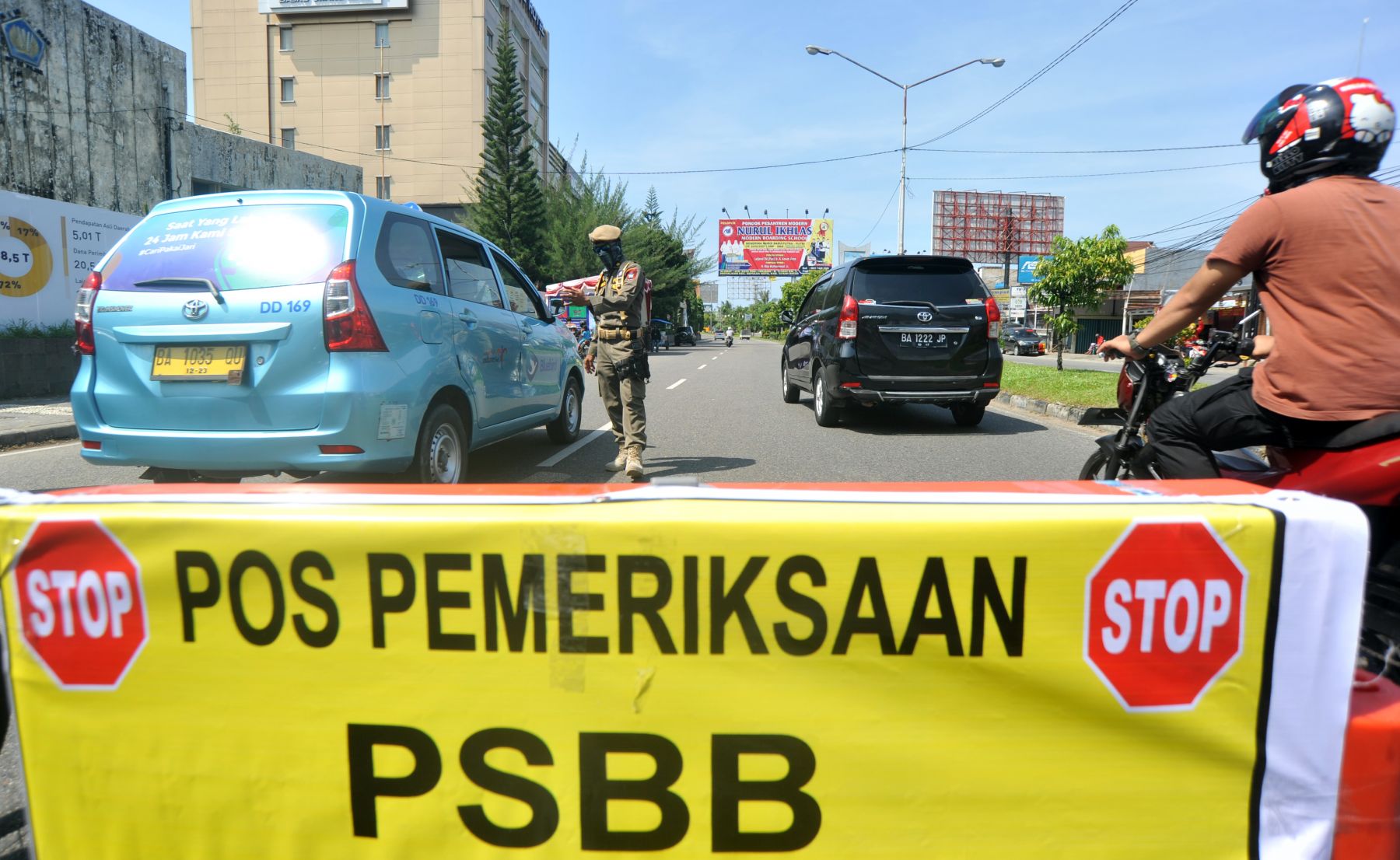 Petugas Satpol PP Kota Padang memberhentikan mobil dalam rangkaian pemeriksaan PSBB untuk mencegah covid-19 varian Omicron