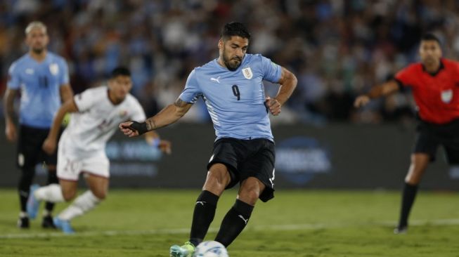 Penyerang Uruguay Luis Suarez menendang penalti ke gawang venezuela