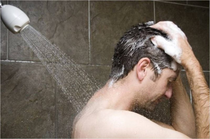 Seorang laki-laki melakukan tata cara mandi wajib dengan menggunakan shower