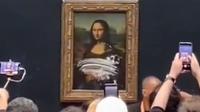 Gambar lukisan Mona Lisa yang tercoreng krim kue setelah seseorang menempelkan kue di atasnya menjadi viral pada Minggu (29/5/2022).(LUKEEE via TWITTER)