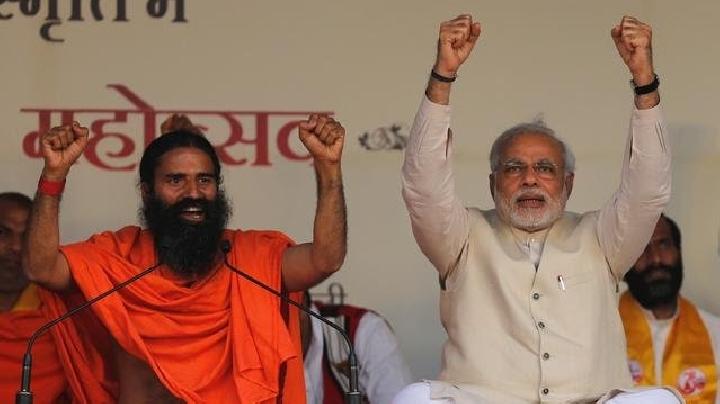 PM India Narendra Modi dan guru yoga Baba Ramdev (kiri) mengangkat tangan saat mereka menyanyikan slogan-slogan patriotik selama Yoga Mahotsav atau festival, di New Delhi 23 Maret 2014. Foto: REUTERS/Adnan Abidi/Files